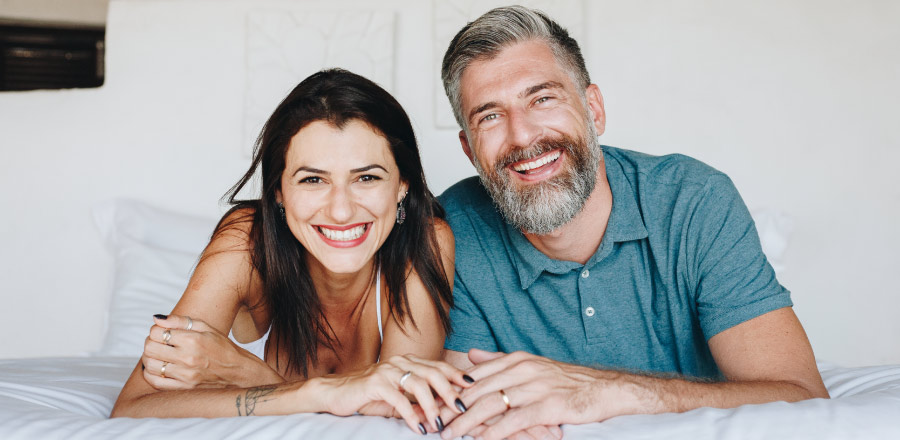 A husband and wife with healthy gums smile in Katy, TX